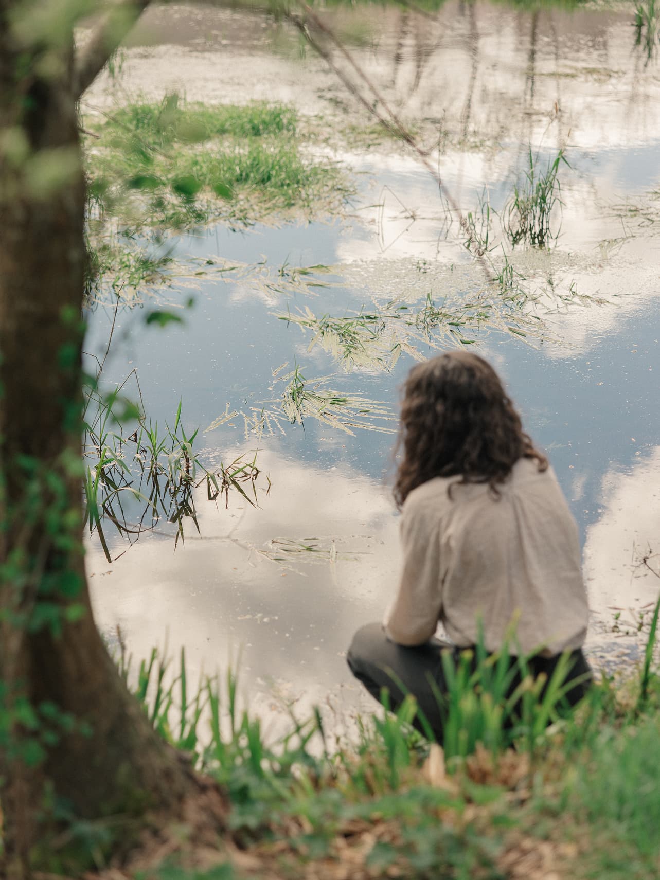 A guest standing beside the millpond at Ómós